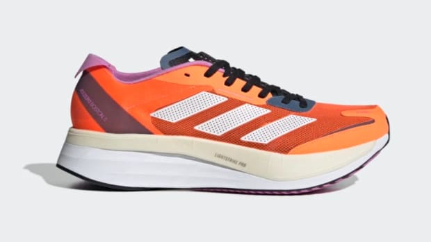 Side view of orange Adidas running shoe.